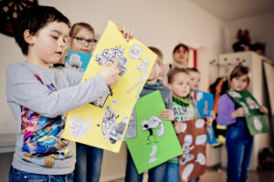 Ein Grundschulkind zeigt etwas auf einem selbstgestalteten Plakat.