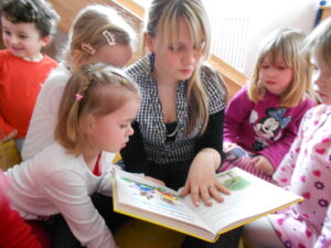 Eine Jugendliche liest Kindern vor.